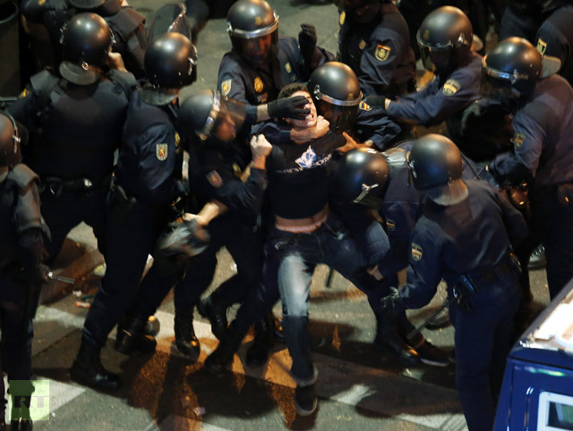 A demonstrator struggles with Spanish National Police riot officers outside the the Spanish parliament in Madrid